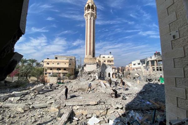 People remove rubble near a mosque destroyed by Israeli strikes, amid the o<em></em>ngoing co<em></em>nflict between Israel and the Palestinian Islamist group Hamas, in the central Gaza Strip, December 8