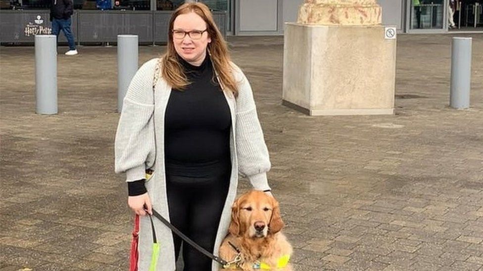 Angharad Paget-Jo<em></em>nes with her dog Tudor. She is standing outside a busy shopping centre